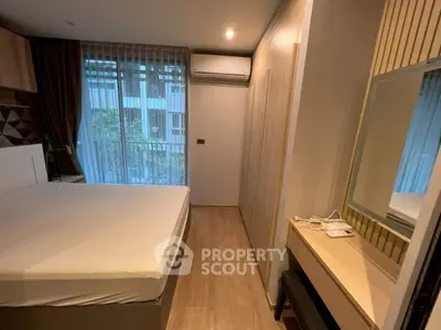 Cozy bedroom with balcony access and modern furnishings in a stylish apartment.