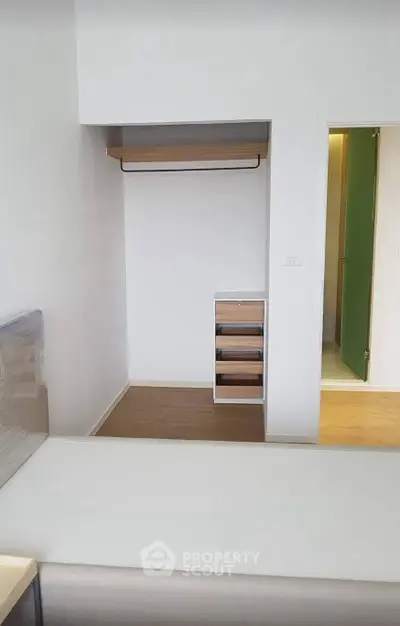 Modern minimalist bedroom with open closet and wooden flooring