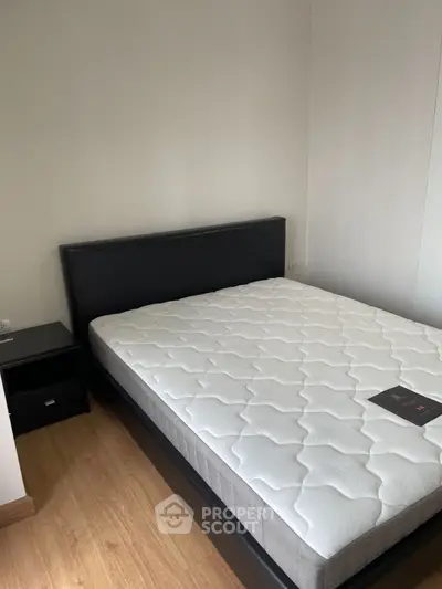Cozy bedroom with modern bed and wooden flooring, perfect for relaxation.