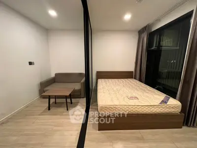 Modern studio apartment with cozy bed and stylish sofa, perfect for urban living.