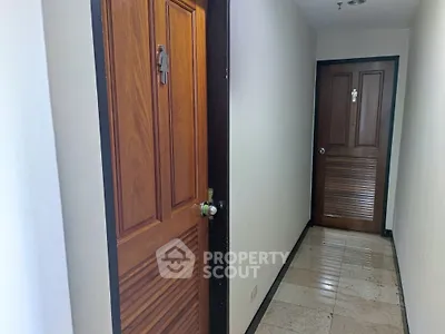 Apartment hallway with wooden doors and tiled floor