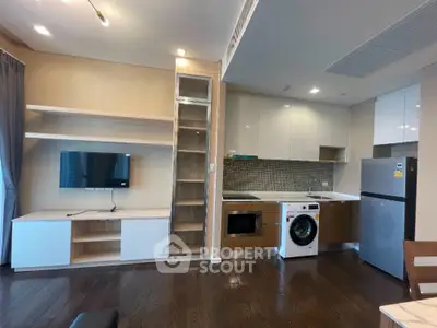 Modern open-layout kitchen with integrated appliances and sleek cabinetry in a stylish apartment.