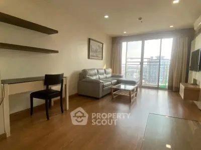 Spacious living room with modern decor and large windows offering city views.