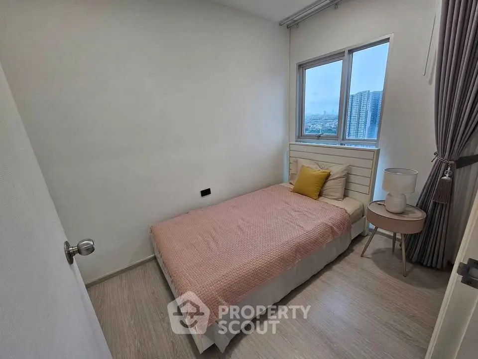 Cozy bedroom with city view, featuring a single bed and modern decor.