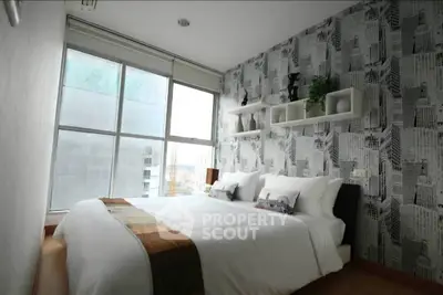 Modern bedroom with city view and stylish wallpaper, featuring a cozy bed and natural light.