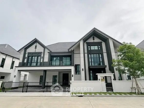 Stunning modern two-story house with sleek design and spacious driveway in a serene neighborhood.