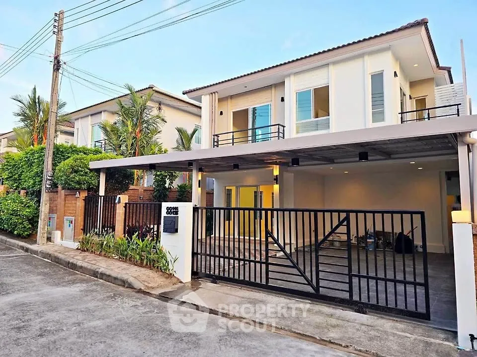 Modern two-story house with spacious driveway and sleek design in a suburban neighborhood.
