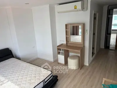 Modern bedroom with air conditioning and wooden flooring in a stylish apartment.