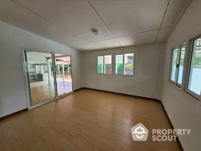 Spacious empty room with large windows and sliding glass door