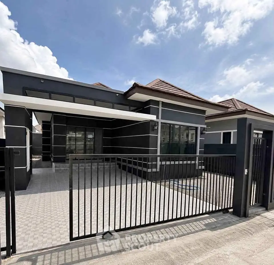 Modern single-story house with sleek design and spacious driveway under a clear blue sky.
