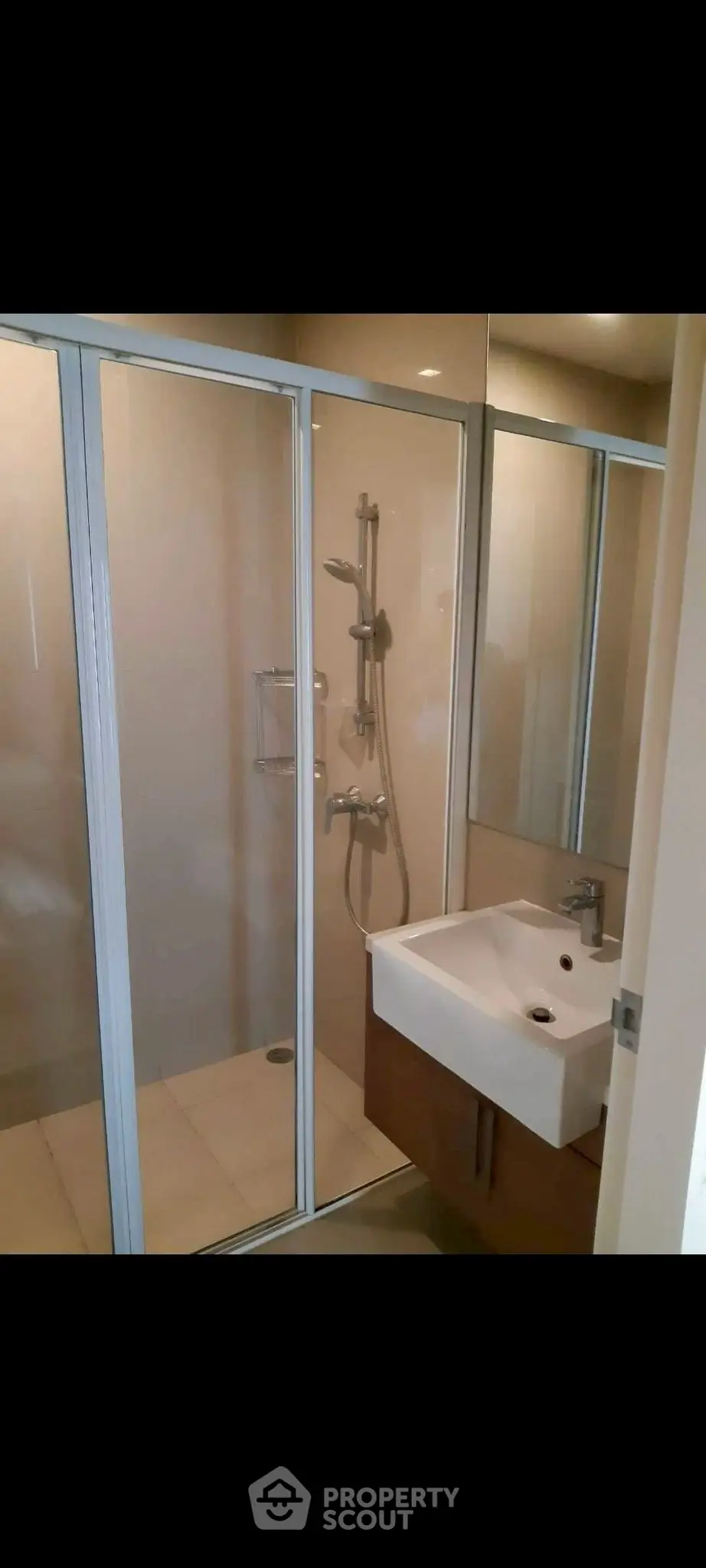 Modern bathroom with glass shower enclosure and sleek sink design.