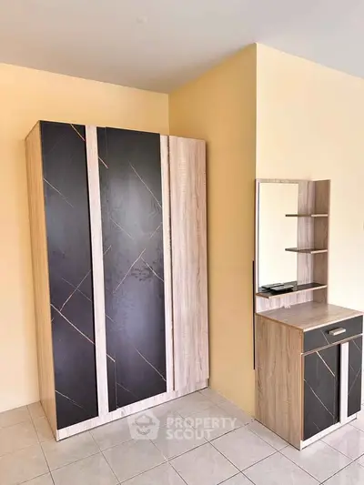 Modern bedroom with stylish wardrobe and vanity set against a neutral wall.