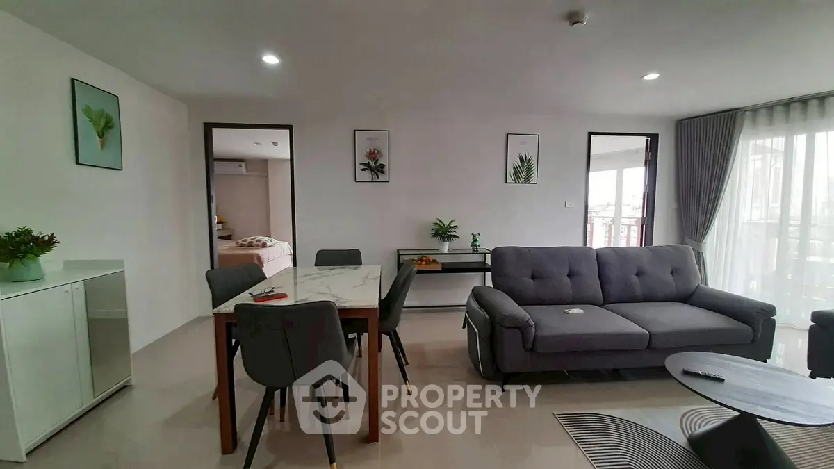 Modern living room with stylish decor and open layout, featuring a cozy sofa and elegant dining area.