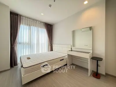 Spacious bedroom with modern decor and large window for natural light.