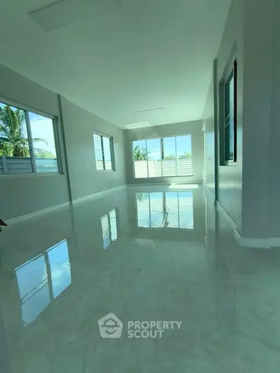 Spacious and bright interior with glossy floors and large windows