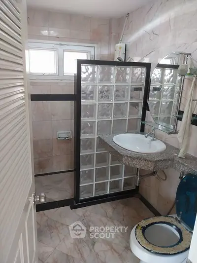 Modern bathroom with glass block shower and marble tiles