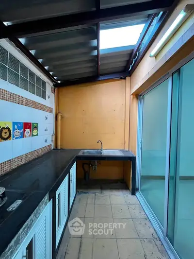 Charming enclosed kitchen with skylight and sliding glass doors, perfect for natural light and ventilation.
