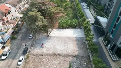 Aerial view of vacant land plot with surrounding residential and commercial buildings.