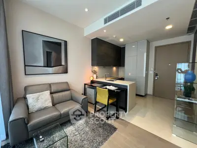 Modern living room with open kitchen, stylish decor, and cozy seating area in a contemporary apartment.