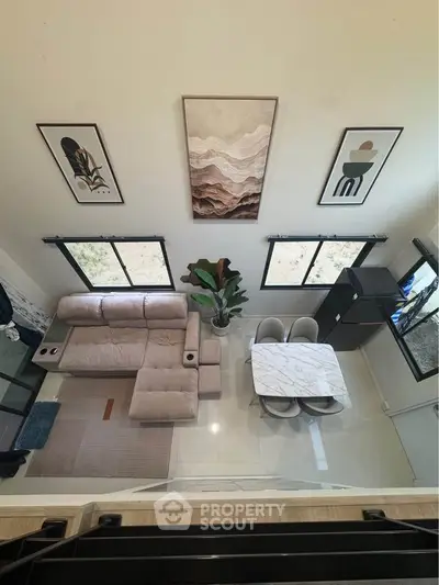 Modern living room with stylish decor and dining area, featuring large windows and elegant furniture.