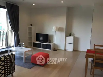 Modern living room with stylish furniture and large window in a bright apartment.