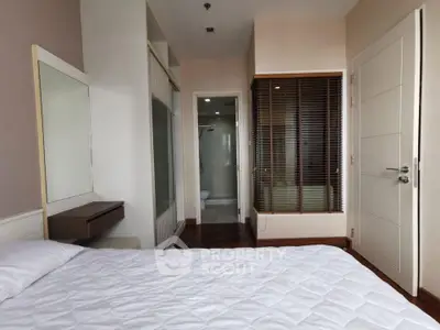Spacious bedroom with ensuite bathroom and modern decor in a stylish apartment.
