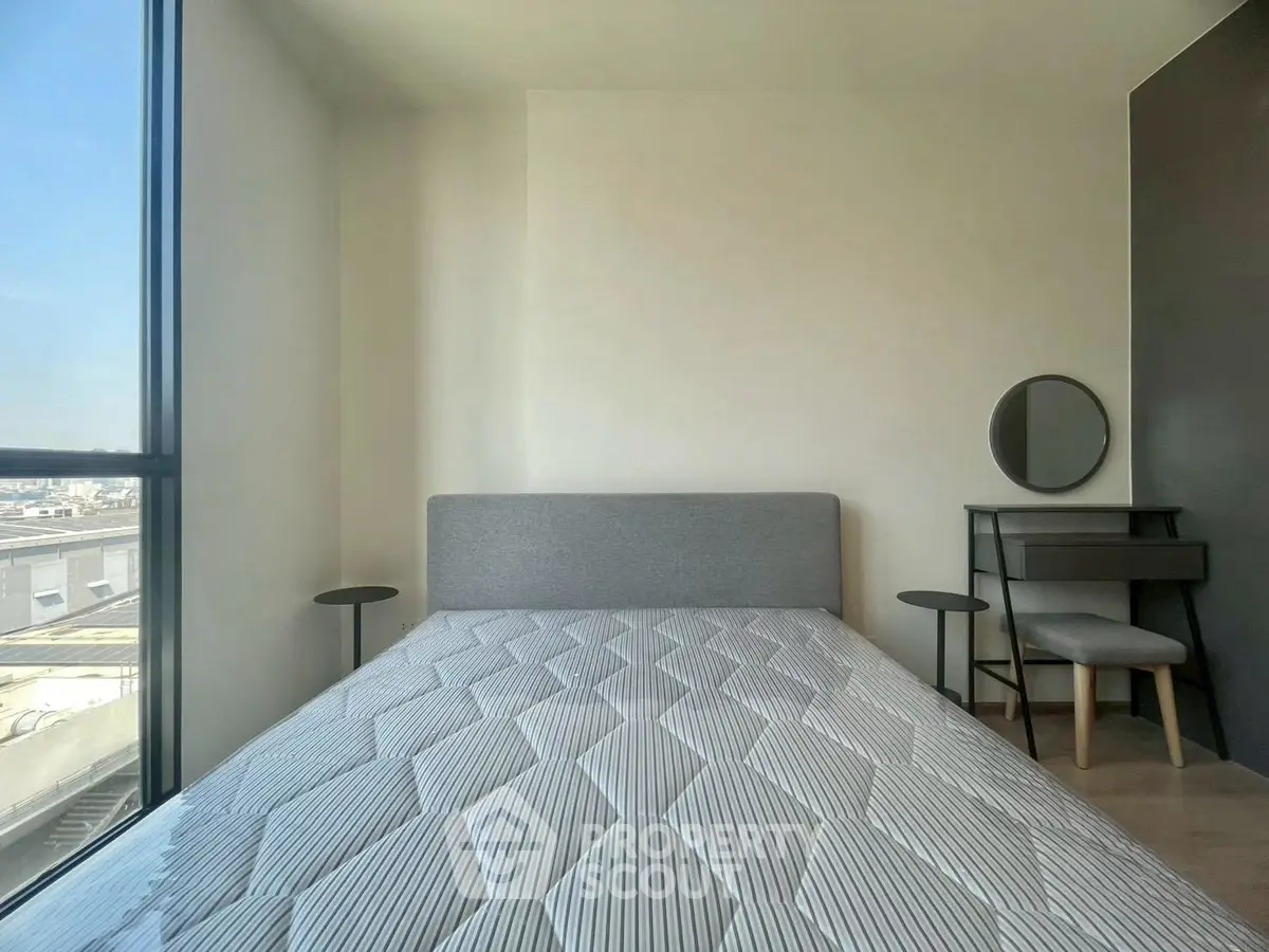 Modern bedroom with large window and stylish furniture