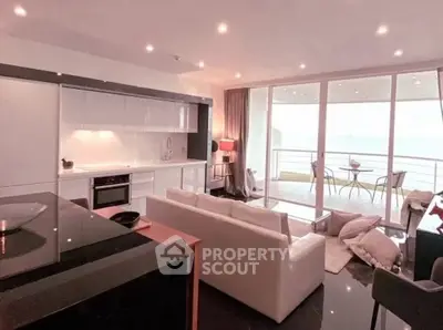 Luxurious open-plan living room with modern kitchen and stunning balcony view.