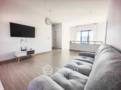 Spacious modern living room with sleek decor and large window view.