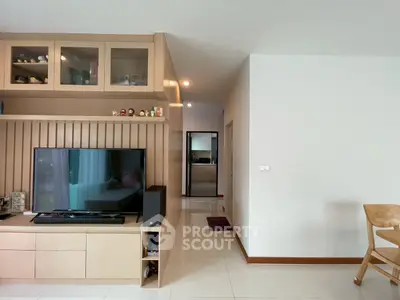 Modern living room with built-in TV cabinet and open layout, featuring sleek wooden finishes.