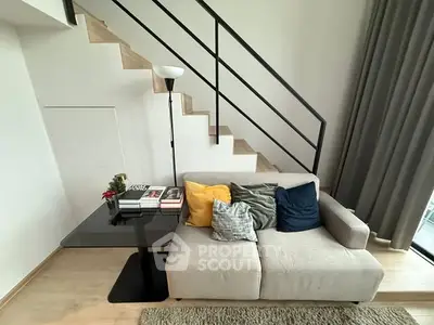 Modern living room with cozy sofa, stylish staircase, and elegant decor