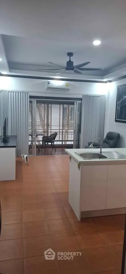 Modern open-plan living room with balcony and sleek kitchen island