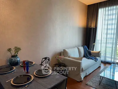 Stylish living room with elegant dining setup and cozy sofa near balcony view.
