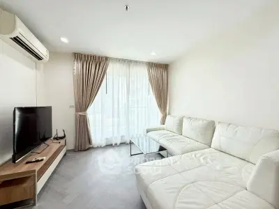 Spacious modern living room with white sectional sofa and large window for natural light.
