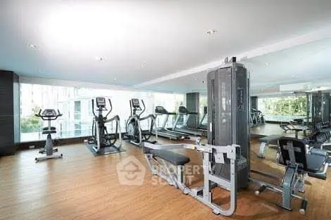 Modern gym with state-of-the-art fitness equipment and large mirrors in a luxury residential building.