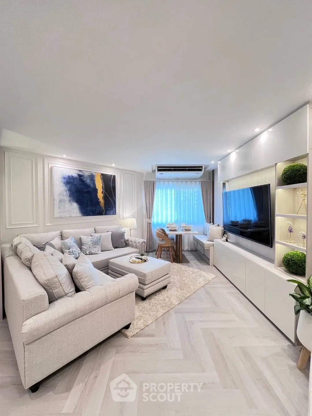 Elegant living room with modern decor and large TV, featuring cozy seating and stylish lighting.