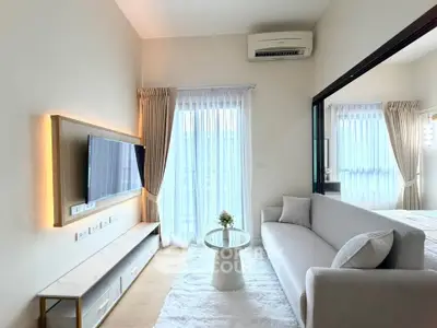 Modern living room with sleek design, featuring a wall-mounted TV, cozy sofa, and elegant decor.
