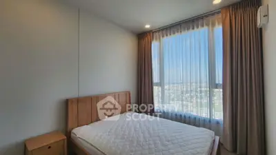 Spacious bedroom with large window offering stunning city view