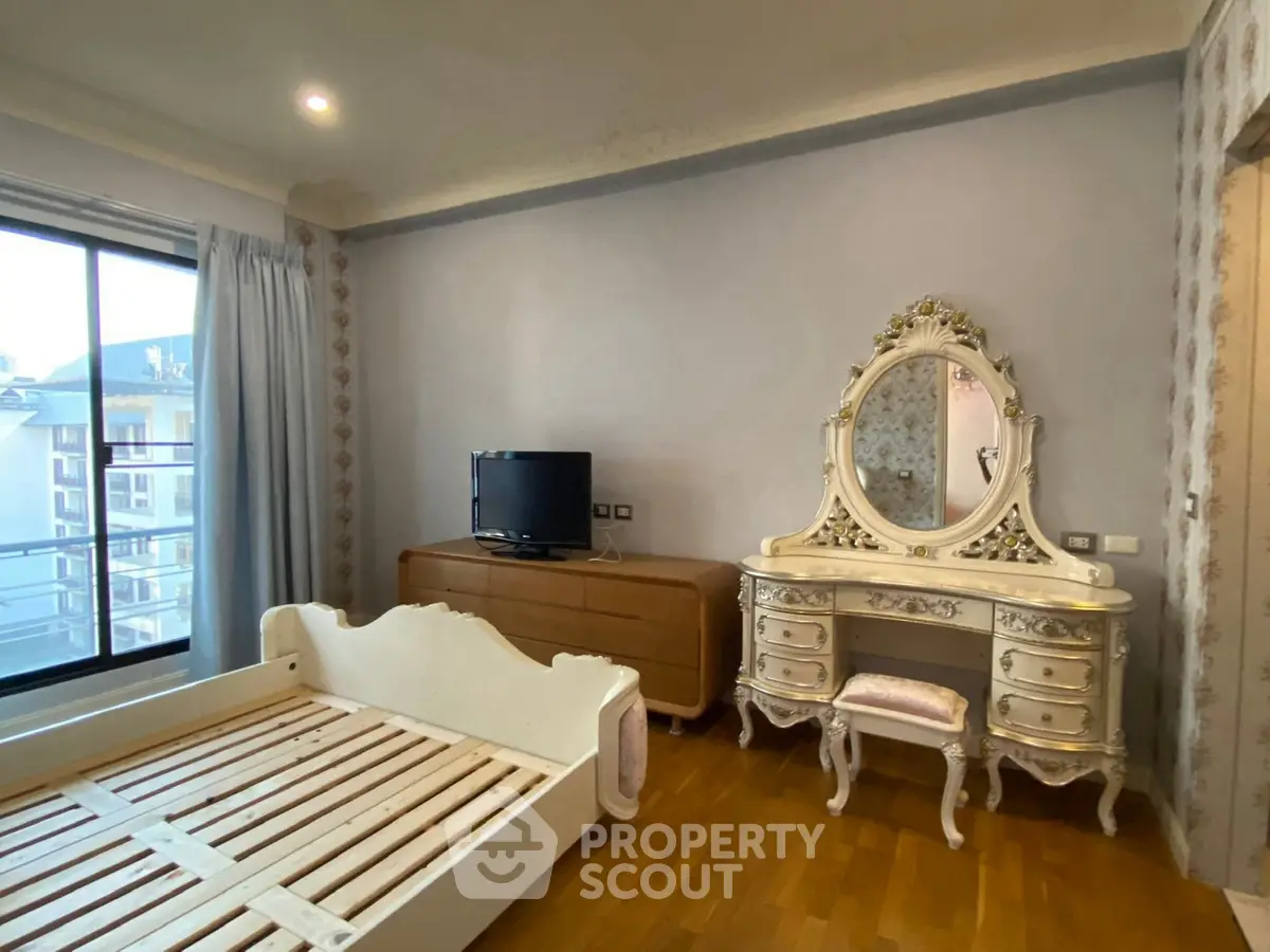 Elegant bedroom with vintage dresser and balcony view in luxury apartment