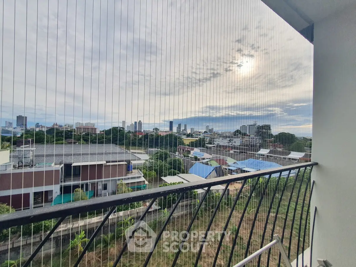 Stunning cityscape view from a high-rise balcony with safety netting, perfect for urban living.