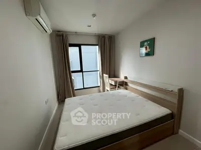 Cozy bedroom with natural light, featuring a comfortable bed and a study desk by the window.