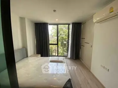 Modern bedroom with large window and air conditioning in a stylish apartment.