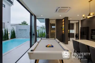 Luxurious modern home with pool table and poolside view, open kitchen layout, and elegant lighting.