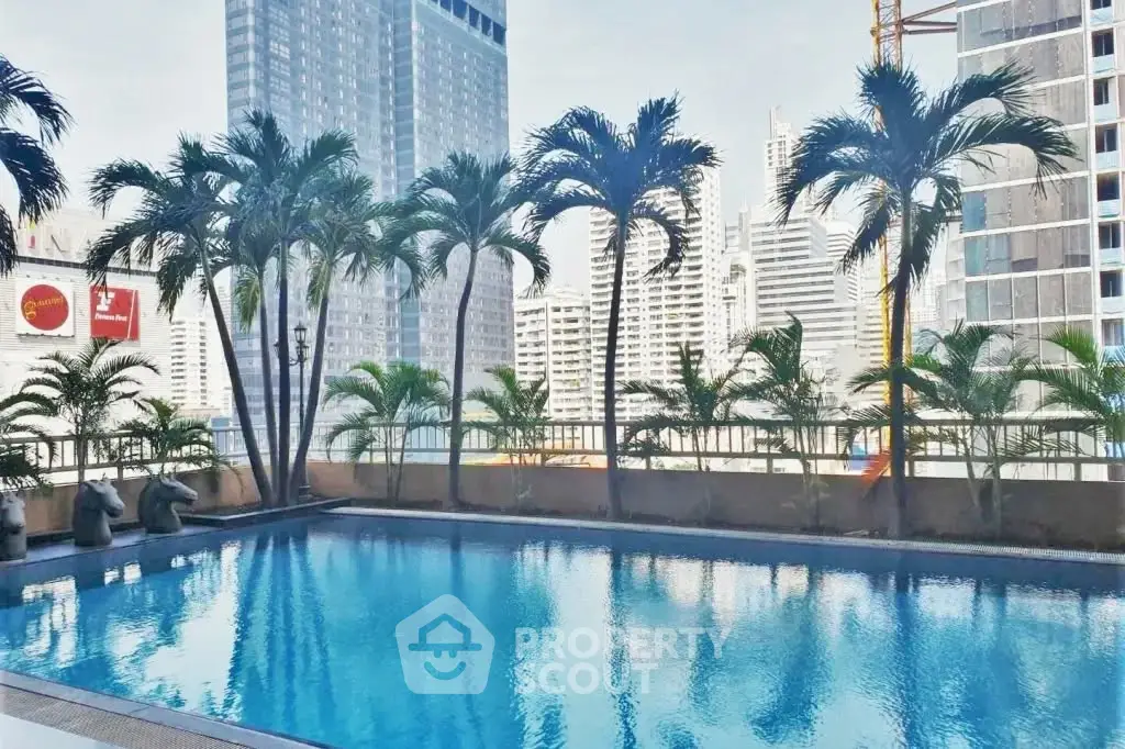 Luxurious urban pool with stunning city skyline views and lush palm trees, perfect for relaxation and leisure.