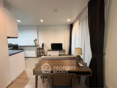 Modern living room with open kitchen and stylish decor in a cozy apartment.