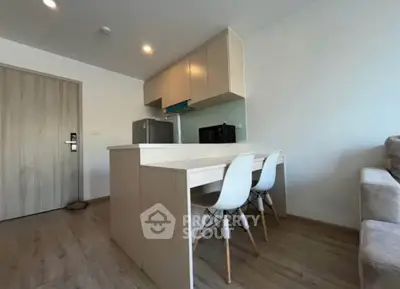 Modern kitchen with sleek cabinetry and dining area in a stylish apartment.