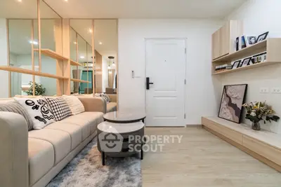 Modern living room with stylish decor and cozy ambiance, featuring a plush sofa and elegant shelving.