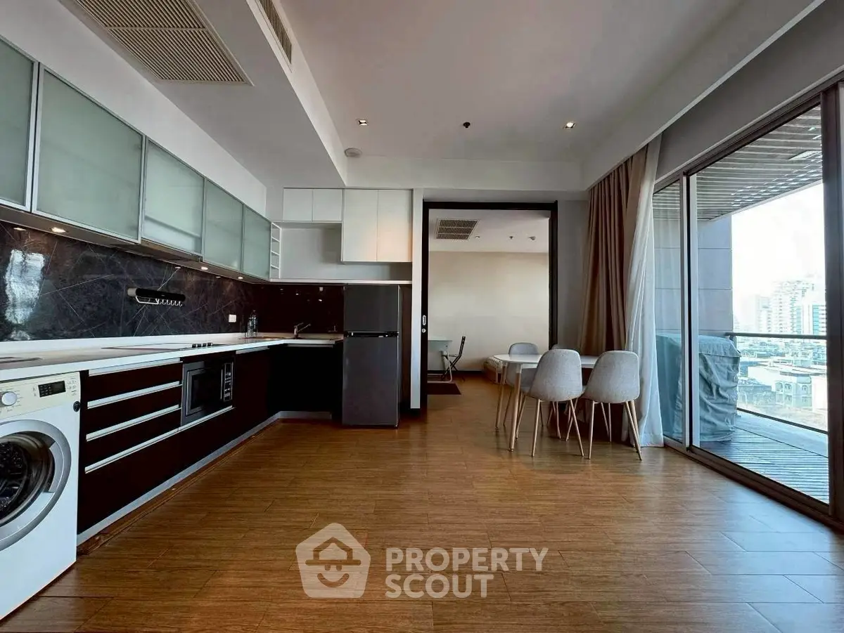 Modern open-layout kitchen with dining area and balcony view