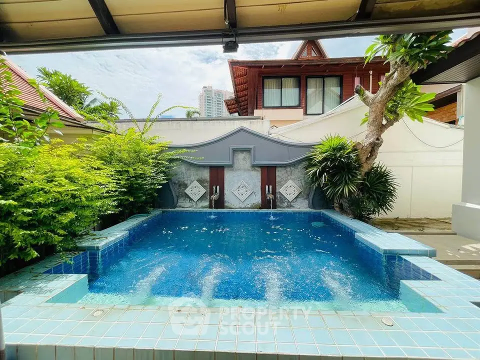 Luxurious private pool surrounded by lush greenery in a serene residential setting.