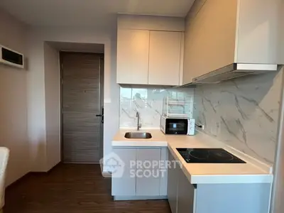 Modern kitchen with sleek cabinetry and marble backsplash in a compact layout.